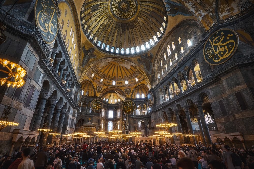 Hagia Sophia interior view with grand dome, hanging chandeliers, and historic prayer hall inside the landmark in Istanbul